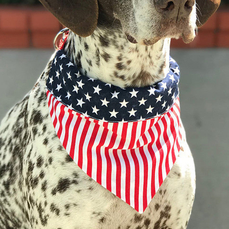 Dog wearing an American flag patterned triangle scarf made of cotton with stars and stripes design.