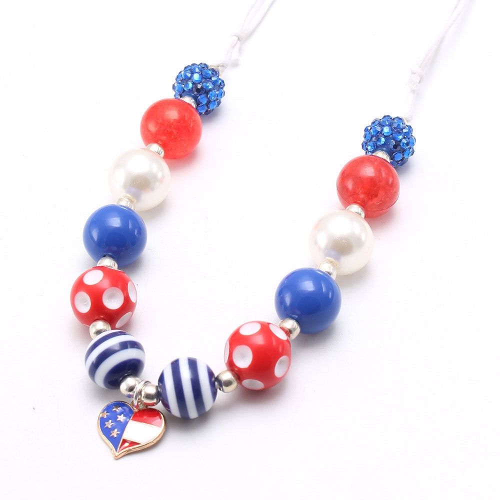 Children's necklace with American flag heart pendant and red, white, and blue beads.